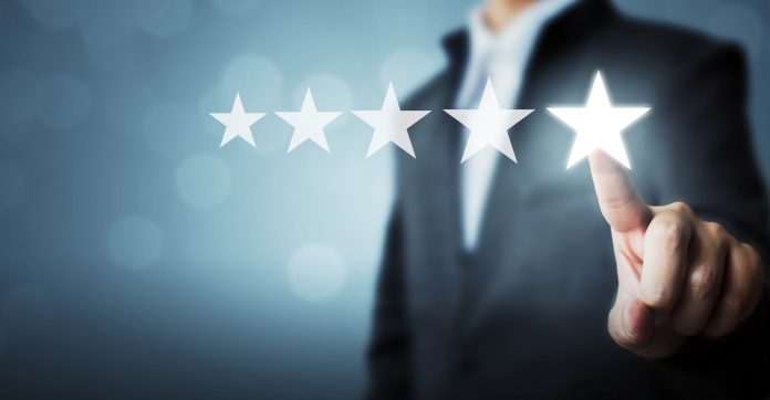 Businessman pointing five star symbol to increase rating of company